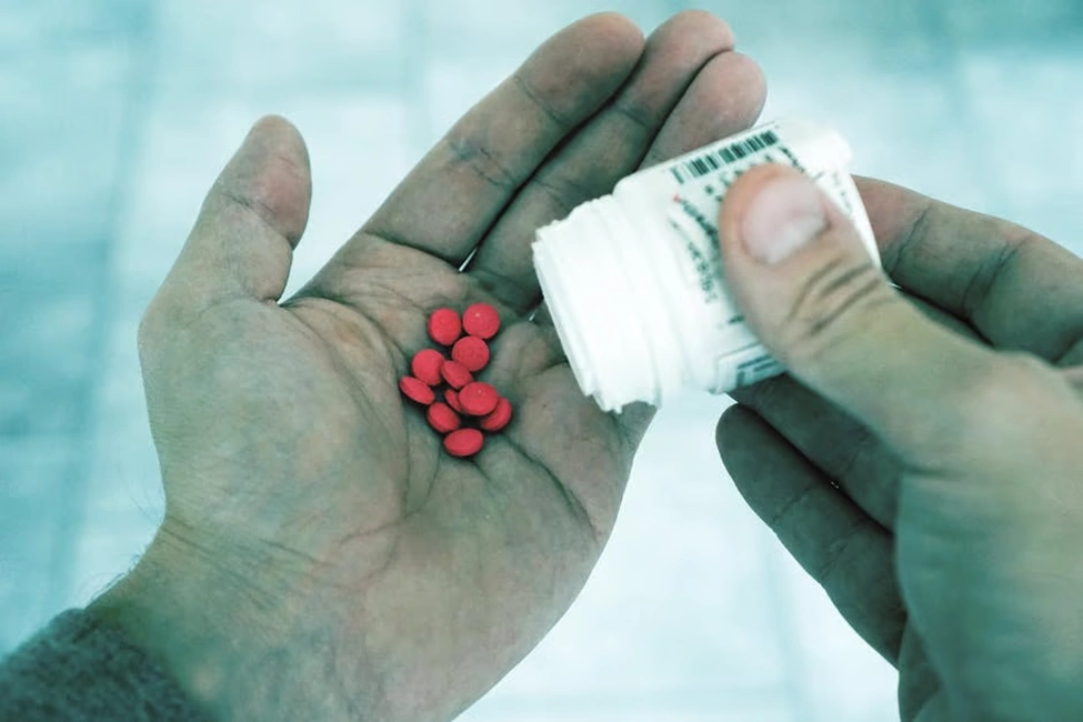 red pills in person hand