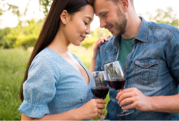 A boy and a girl are holding wine glasses